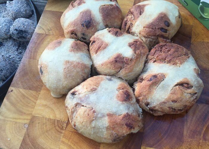 a photo of camp oven hot cross buns sitting on a chopping board